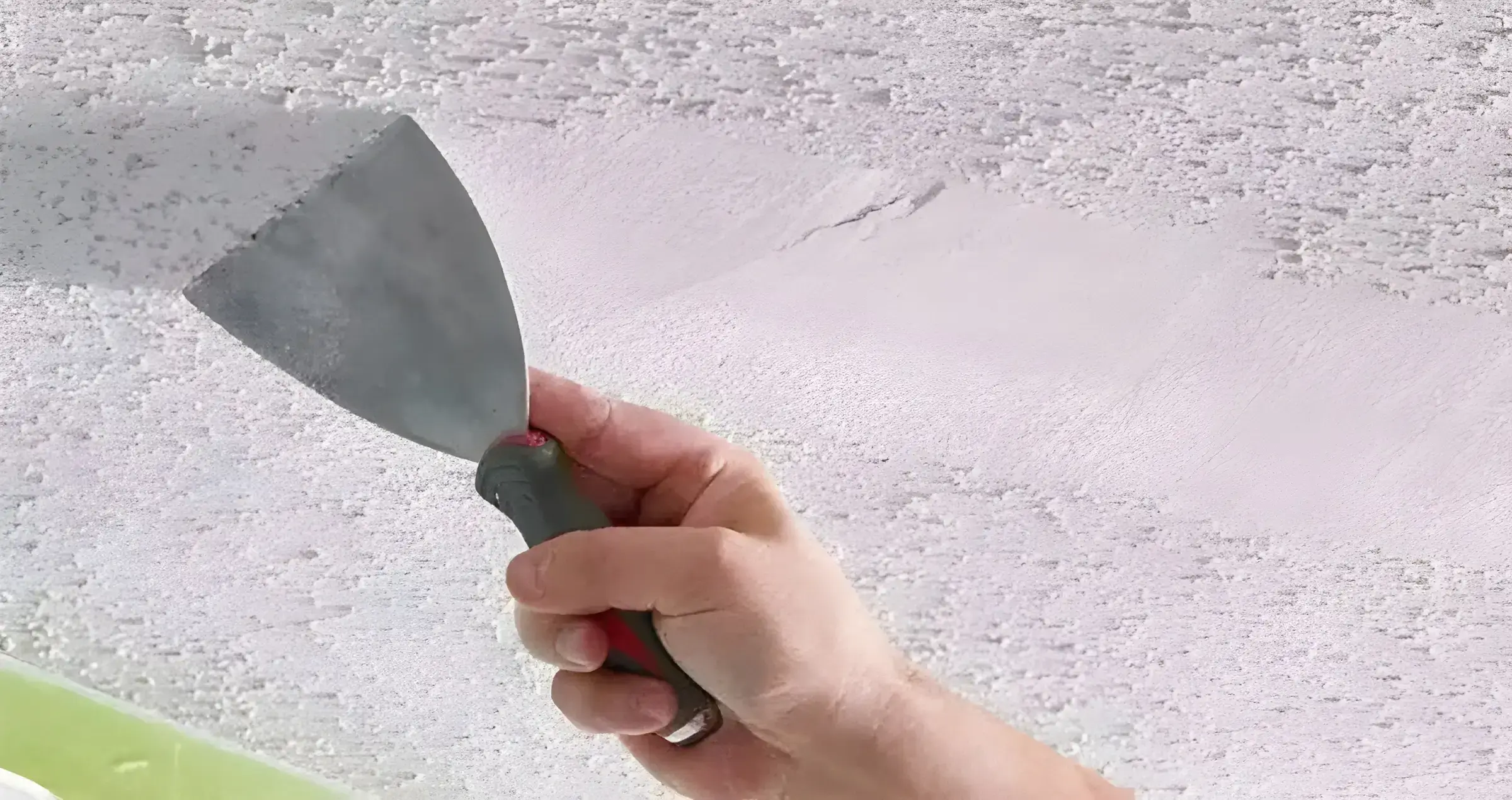Los Pintores Marbella eliminando el gotelé con espátula para dejar la pared lisa